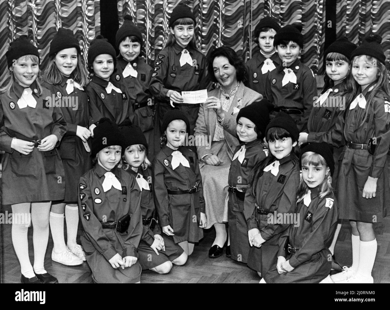 Eine Stunde lang ihren Müttern eine helfende Hand zu geben, half Mitgliedern der 3. fairfield Brownies, £100 für den NSPCC Centenary Appeal zu sammeln. Die Brownies wurden von ihren Freunden gesponsert, als sie Hausarbeiten durchführten. Frau Ann Townsend, Vorsitzende der North Tees Branch des NSPCC, wird den Scheck von Victoria Bolam erhalten. Sie wird von den anderen Brownies beobachtet, die mitmachten (L-R Standing) Marie Grey, Sarah Morgan, Hazel Youngman, Alison Turnbull, Julia Newey, Angela Bennett und Rachel Dixon; kniend sind Alison Curbishley, Kelly Stephenson, Emma Davies, Stephanie Nicho Stockfoto