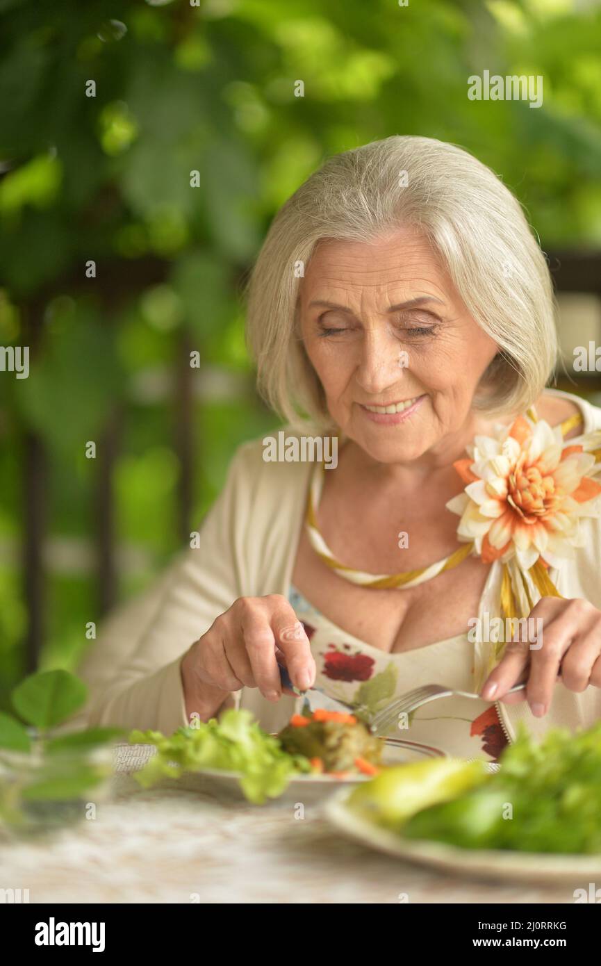 Ältere Frau, die im Restaurant zu Abend gegessen hat Stockfoto
