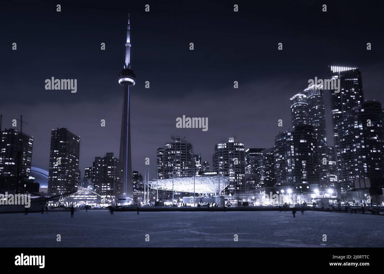 Blick auf die Winternacht vom Eis des gefrorenen Sees Ontario auf die Skyline von Toronto in der Innenstadt von Toronto mit Wolkenkratzern mit hell erleuchteten Fenstern. Toronto Stockfoto