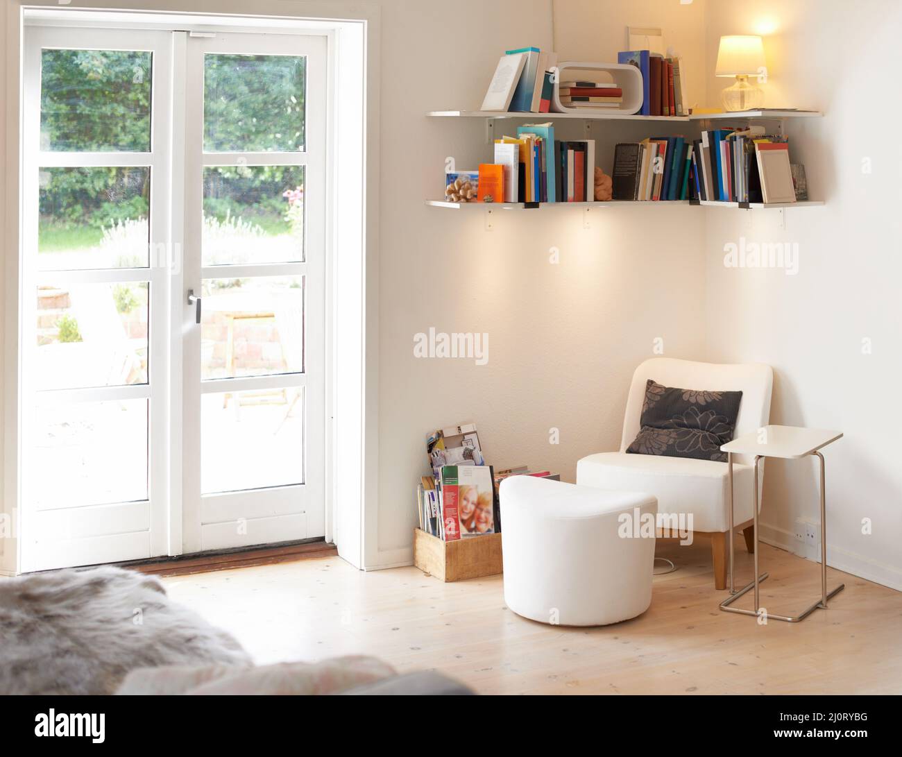 Ein heimeliger und stilvoller Ort. Ein leeres Wohnzimmer mit Sessel und Bücherregal. Stockfoto