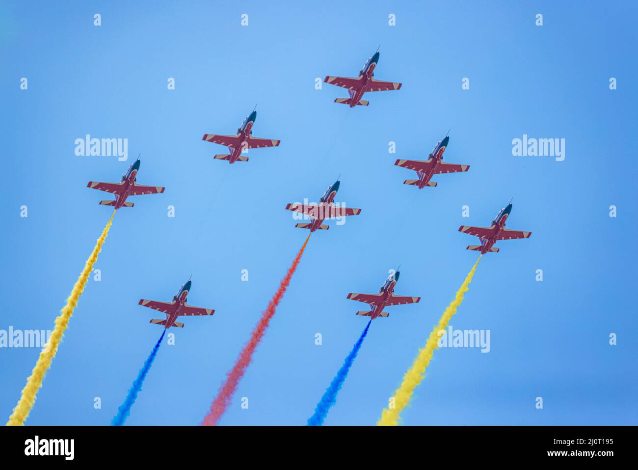 Low-Angle-Aufnahme der Militärluftfahrt am blauen Himmel mit buntem Rauch Stockfoto