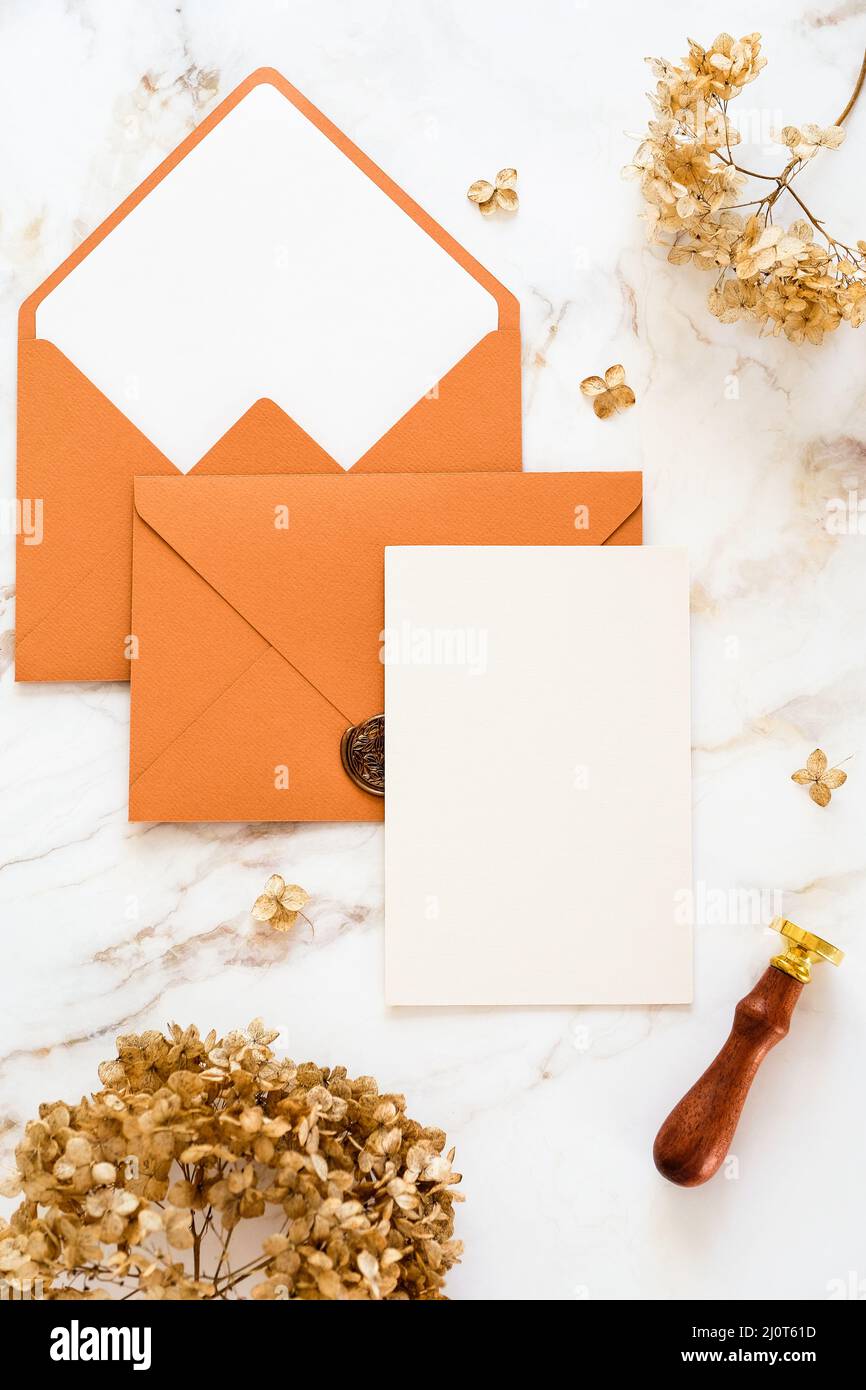 Hochzeitseinladungskarte, braune Umschläge, trockene Blumen auf Marmortisch. Flach liegend, Draufsicht, Kopierbereich. Stockfoto
