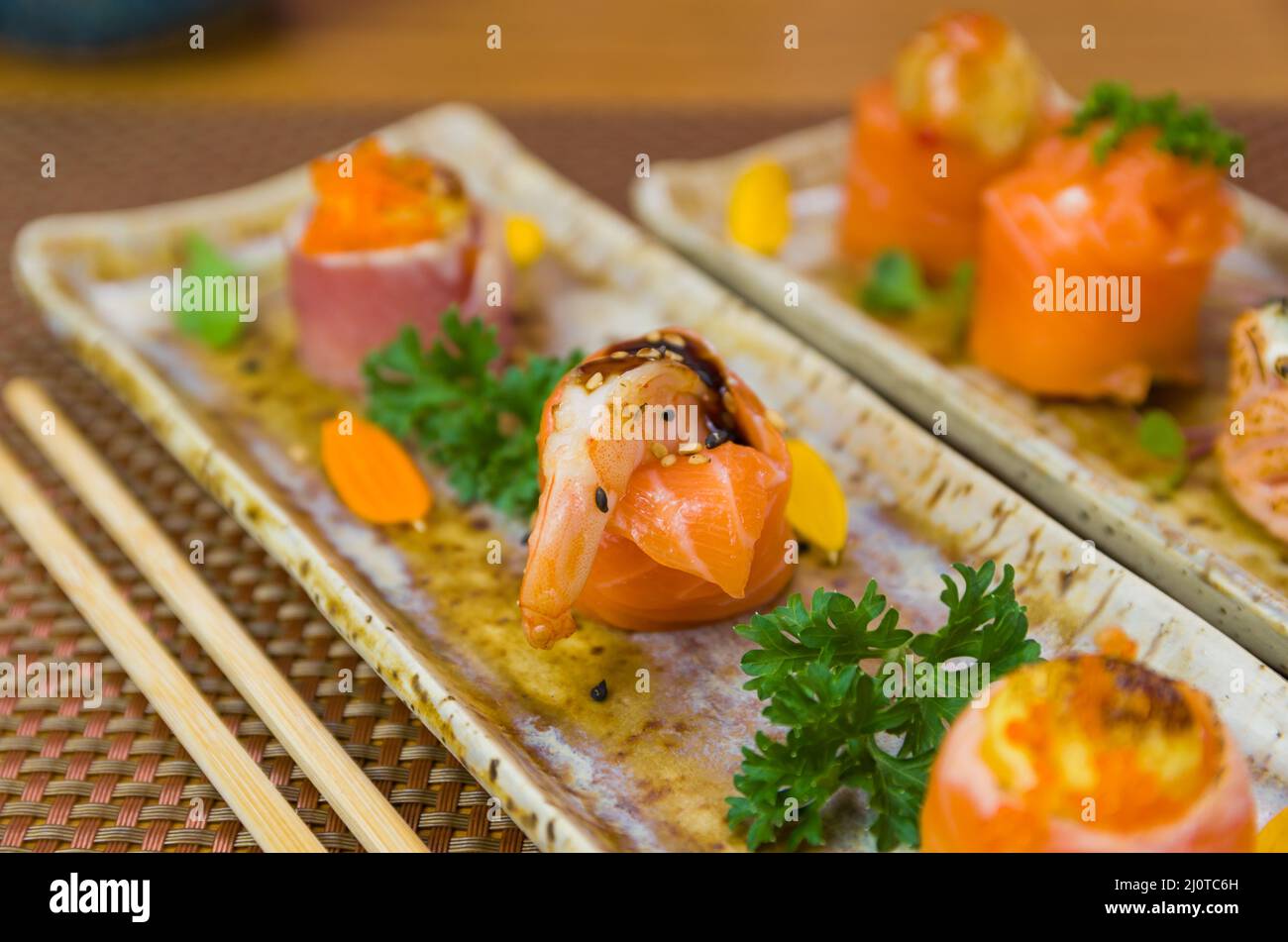 Platte mit verschiedenen Geschmacksrichtungen von elegantem Sushi dekoriert. Selektiver Fokus. Stockfoto