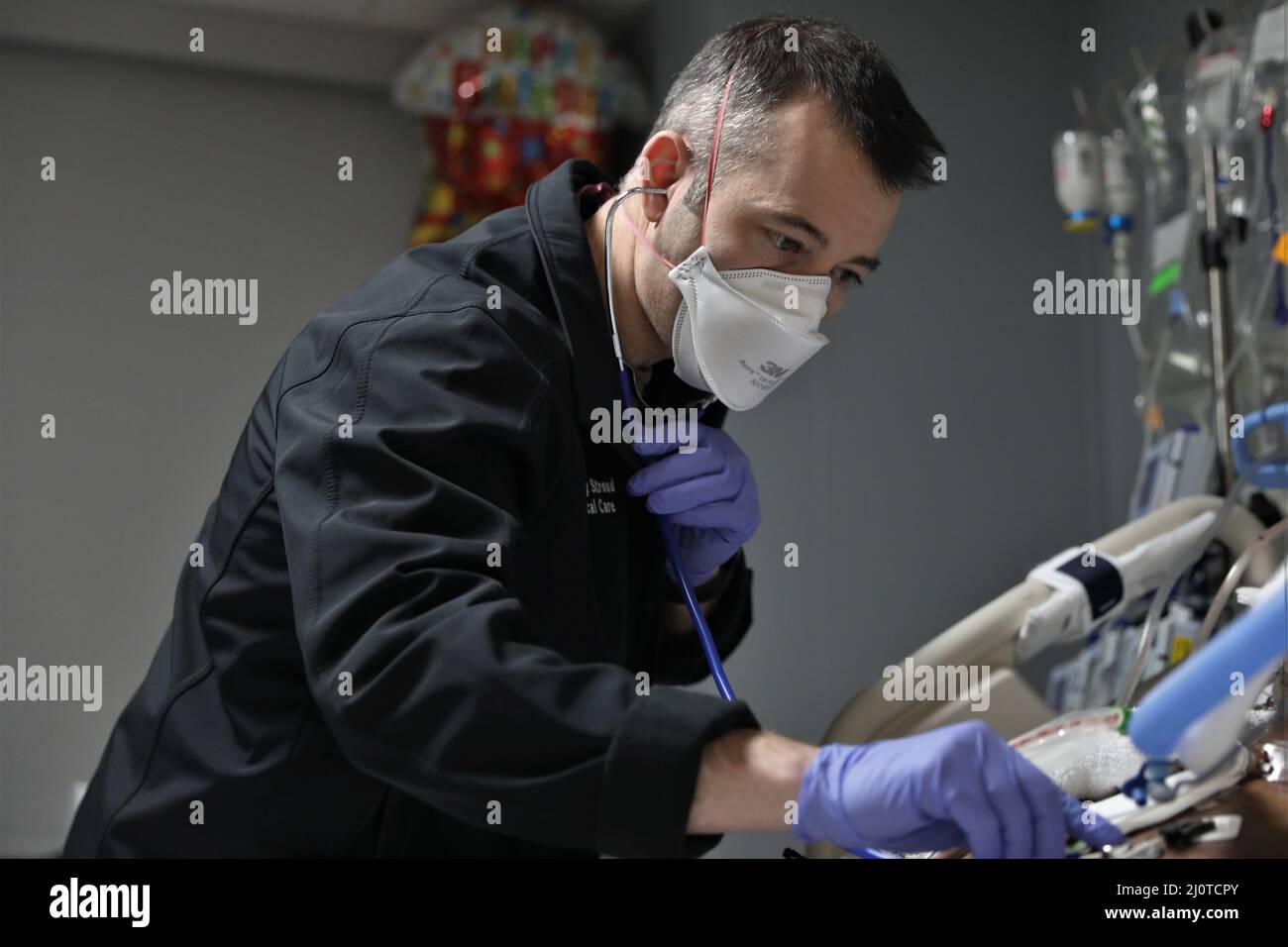 BUFFALO, N.Y. – der US Navy LT. Jeffrey Stroud, eine Krankenschwester für die Intensivmedizin, die dem Walter Reed National Medical Center, Navy Medicine Readiness and Training Command, Bethesda, Maryland, zugewiesen ist, überprüft die Herzfrequenz und das Atemmuster eines Patienten und unterstützt die COVID-Reaktionsoperationen im Erie County Medical Center in Buffalo, New York, Januar 23, 2022. Das U.S. Northern Command setzt sich über die U.S. Army North weiterhin für die flexible Unterstützung des Verteidigungsministeriums für die COVID-Reaktion der gesamten Regierung ein. (USA Armee-Foto von SPC. Ashleigh Maxwell) Stockfoto