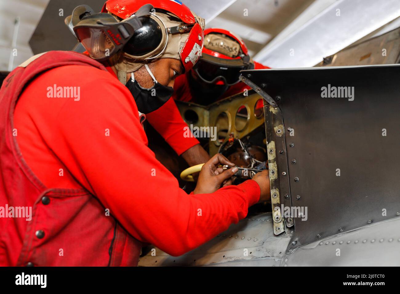 PHILIPPINISCHES MEER (Jan 23, 2022) Aviation Ordnanceman Airman Marquise Goldsmith, links, aus Greenville, S.C., Und Aviation Ordnanceman 2. Class Nigel Jacques aus San Antonio, der den 'Chargers' von Helicopter Sea Combat Squadron (HSC) 14 zugewiesen wurde, führt Wartungsarbeiten an einem MH-60s Sea Hawk Hubschrauber in der Hangarbucht an Bord des Nimitz-Klasse Flugzeugträgers USS Abraham Lincoln (CVN 72) durch. Carl Vinson und Abraham Lincoln Carrier Strike Groups führen duale Carrier-Operationen durch, um die Interoperabilität der Joint Force zu verbessern und gleichzeitig unser Engagement für einen freien und offenen Indo-Pazifik-Raum zu demonstrieren. Die US-Indo-Pa Stockfoto