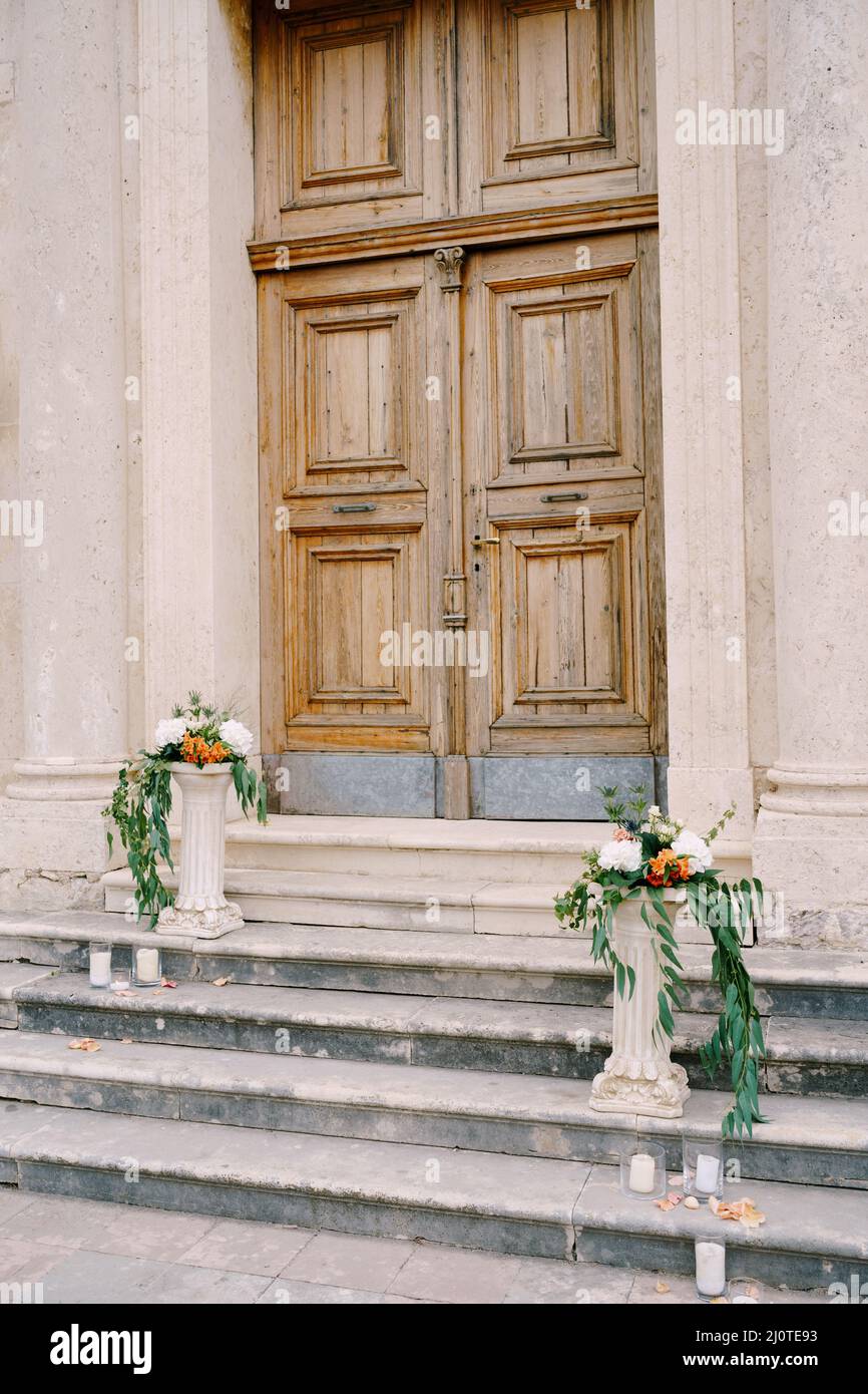 Blumensträuße liegen auf kleinen Steinsäulen auf den Stufen Stockfoto