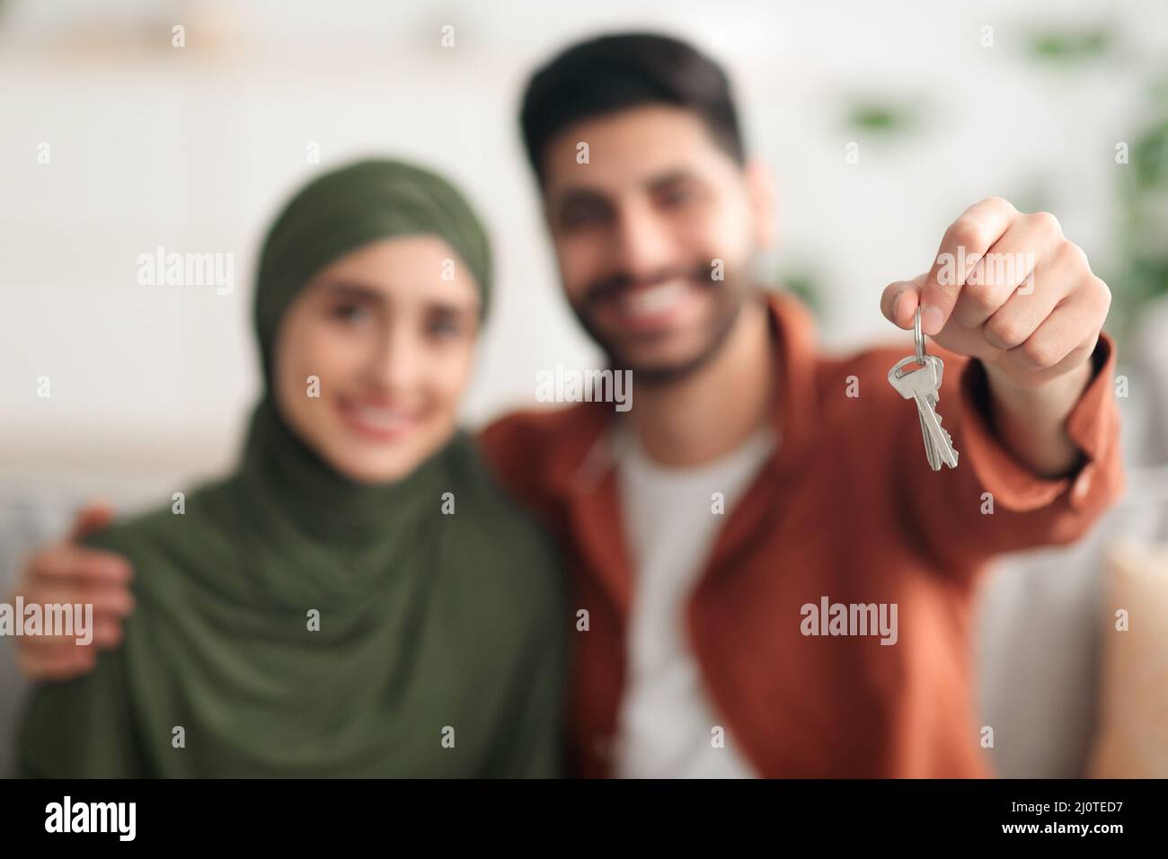 Junge Ehegatten Aus Dem Nahen Osten Zeigen Zu Hause Den Neuen Hausschlüssel Stockfoto