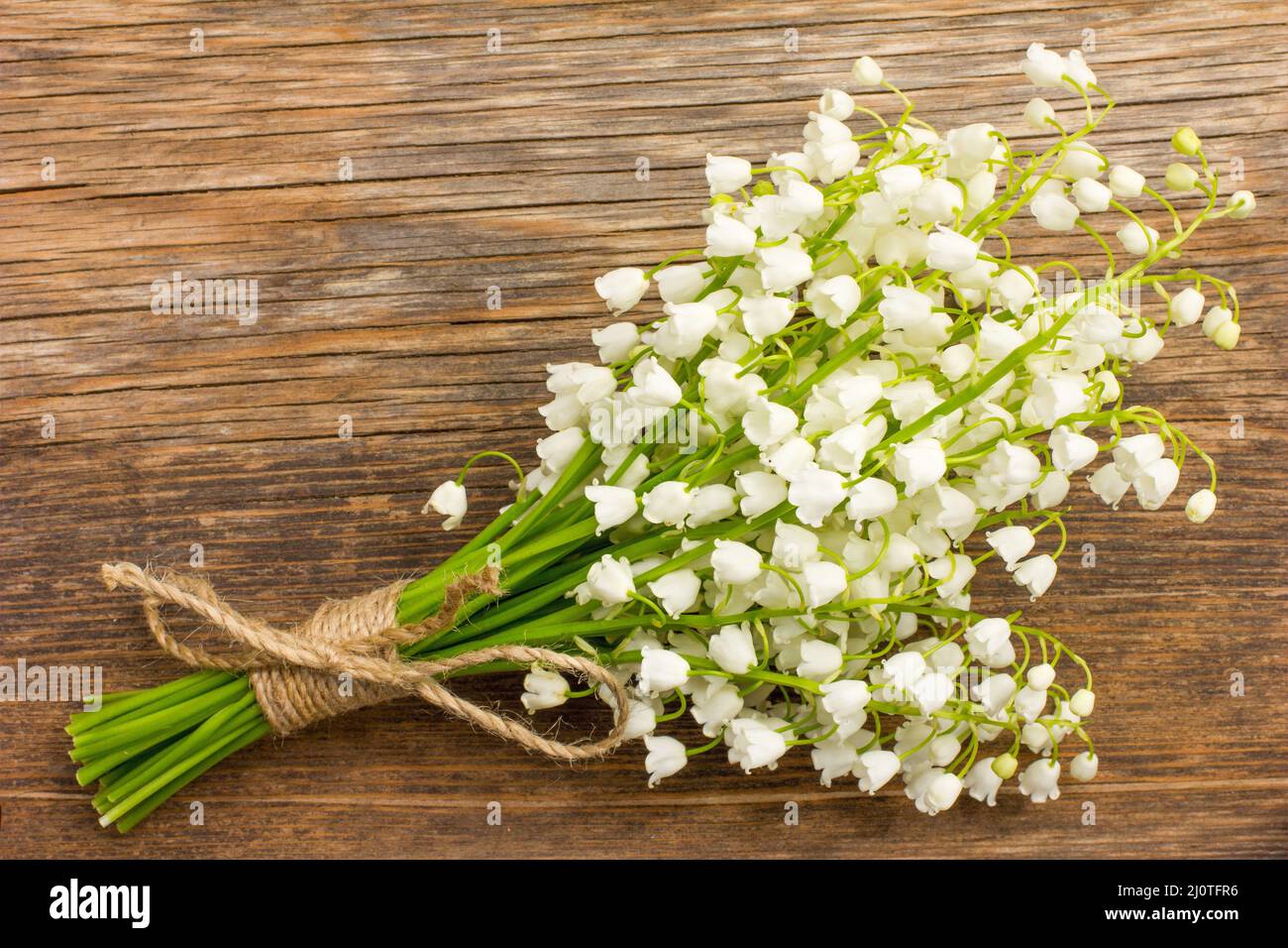 Vintage Bouquet von wilden Blumen, die weißen duftenden Lilien auf das Tal auf einem alten Holzbrett closeup Stockfoto