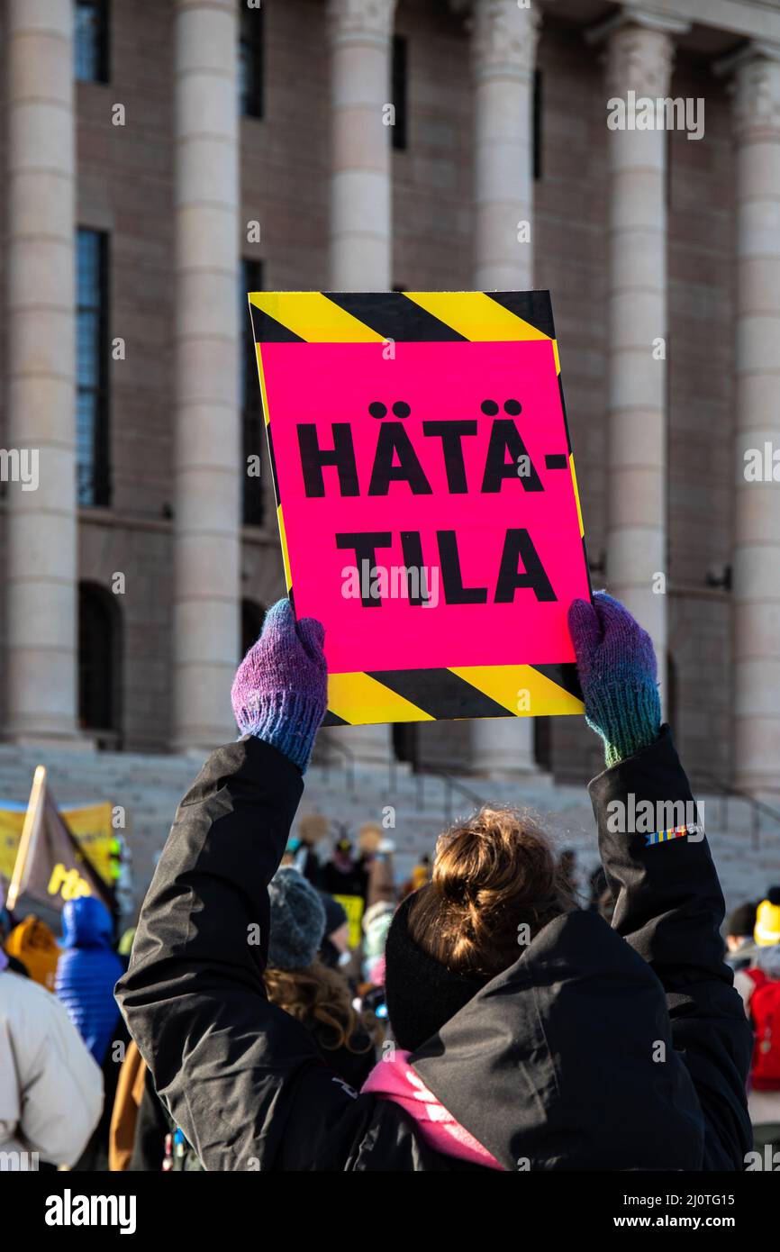 Hätätila. Demonstrator mit einem Schild vor dem Eduskuntatalo oder dem Parlamentsgebäude am Lunastakaa lupaukset-Klimaprotest in Helsinki, Finnland Stockfoto