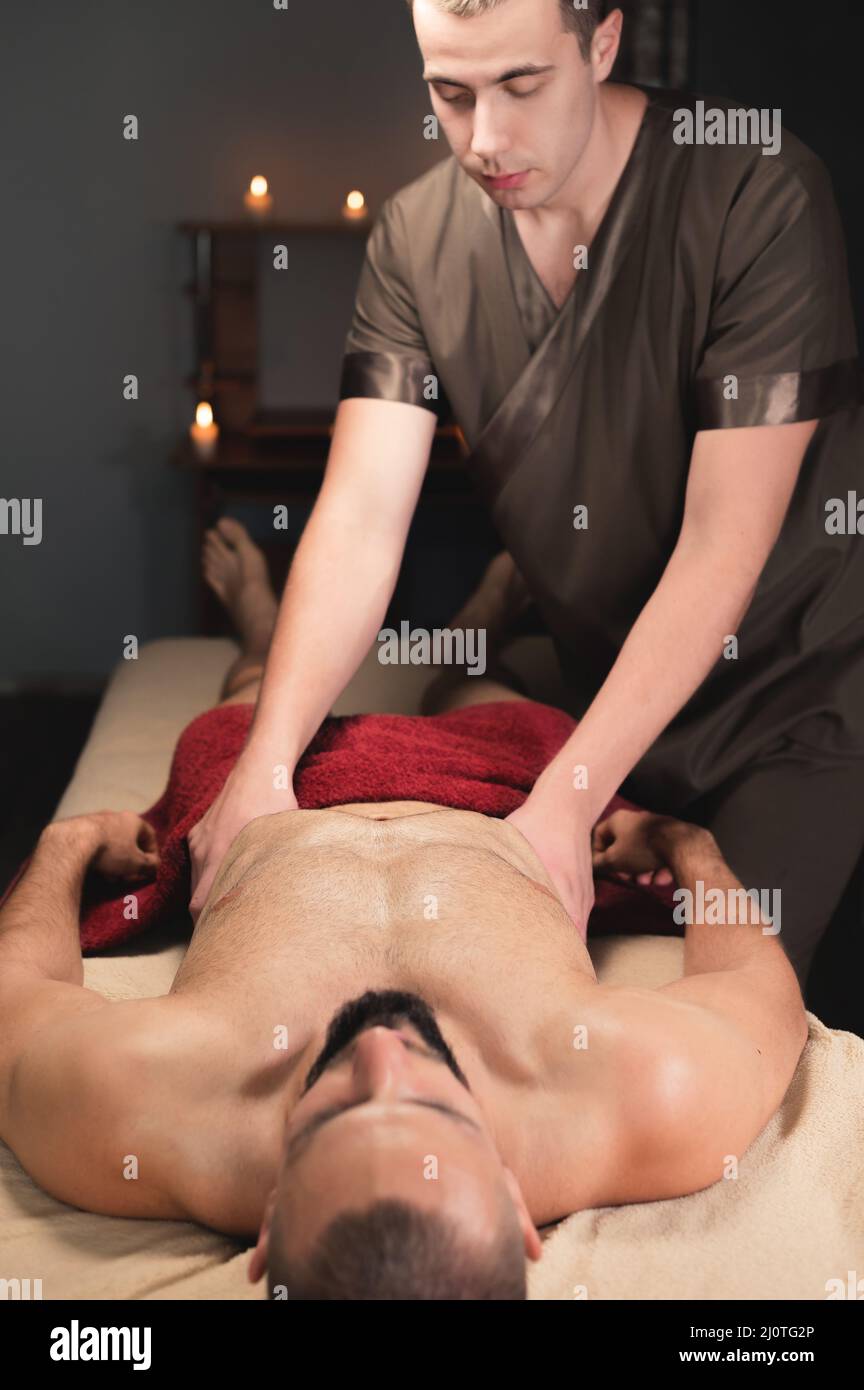 Professioneller Masseur, der eine Sport-Brustmassage für einen Sportler und einen Kunden-Mann macht Stockfoto