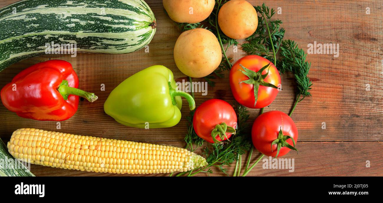 Ein Gemüseset auf einem Holztisch. Flach liegend, Draufsicht. Freier Speicherplatz für Text. Breites Foto . Stockfoto