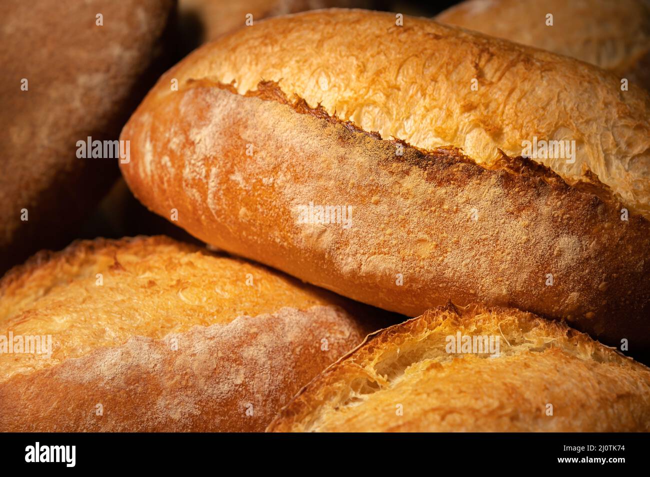 Nahaufnahme von Sauerteig-Brot. Frisch gebackenes Brot mit goldener Kruste auf den Holzregalen der Bäckerei. Der Kontext einer Germa Stockfoto