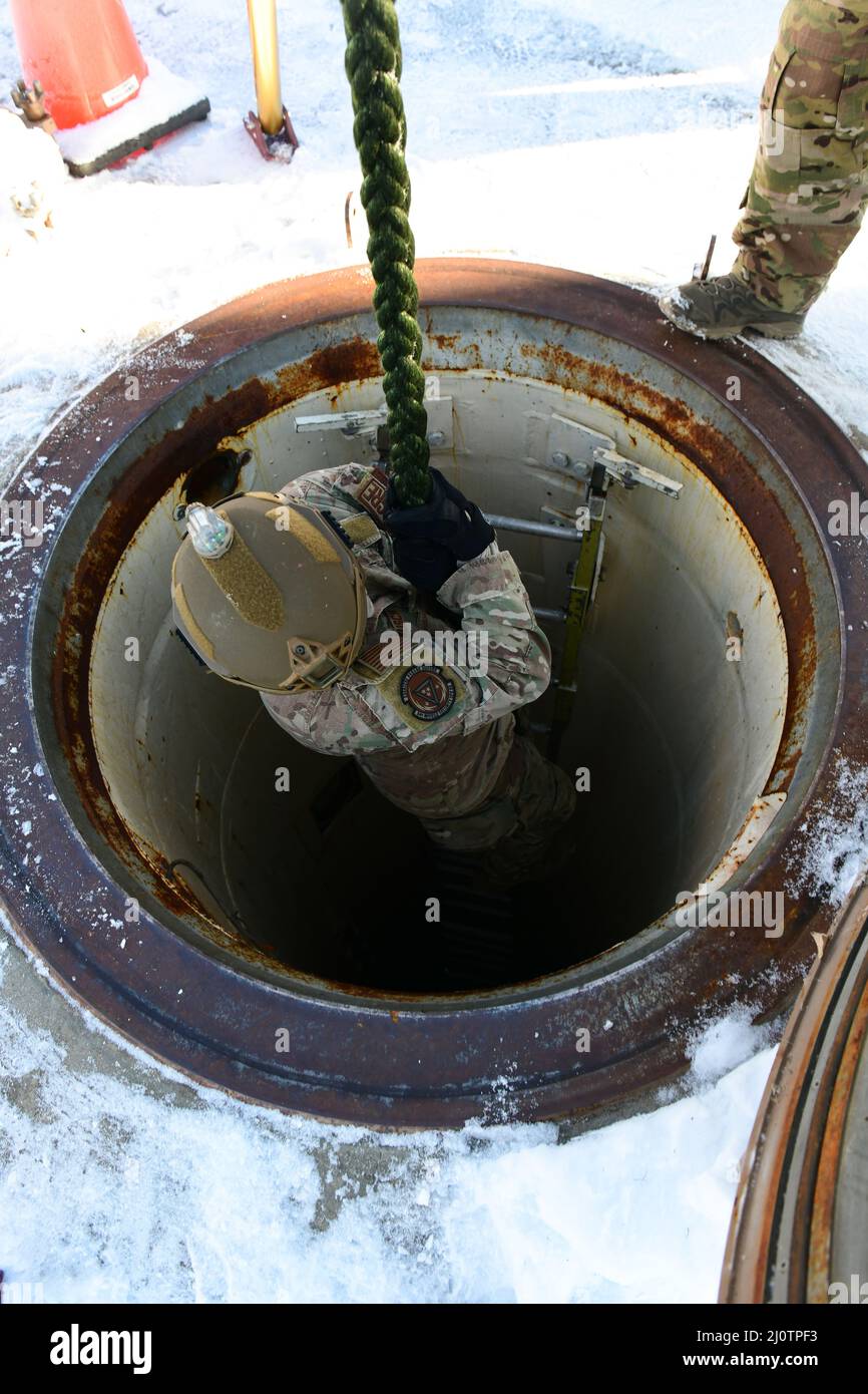 Personal Sgt. Lee Busch, Mitglied der Combat Response Force, 341. Missile Security Operation Squadron, rutscht am 26. Januar 2022 auf F.E. in einen Personenzugangsschacht auf einem Seil Warren Air Force Base, Wyoming. Verteidiger des Raketenflügels 341., des Raketenflügels 90. und des Raketenflügels 91. nahmen an einem Abseilen-Kurs auf F.E. Teil Warren AFB, um neue Abseilen-Anleitungen zu erlernen und sich in Techniken wie Knotenbindung, Inspektionen, Turmanschlüssen und Sicherheit zertifizieren zu lassen. (USA Luftwaffe Foto von Airman Sarah Post) Stockfoto