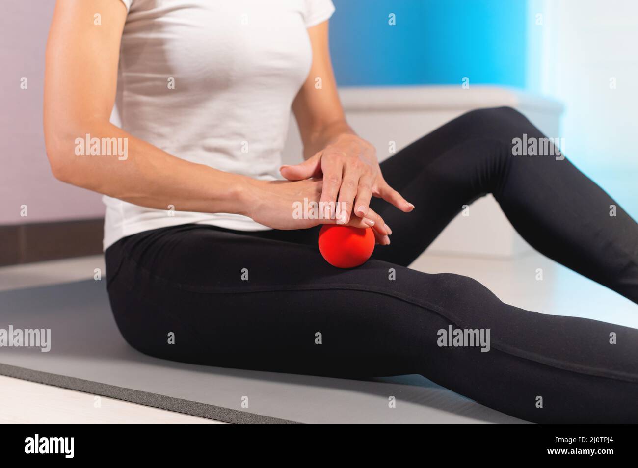 Gesundheit, Menschen, Körperpflege und Beauty-Konzept. Eine schlanke Frau mittleren Alters massiert im Innenbereich mit einem Massageball das Gesäß. Kopieren Stockfoto
