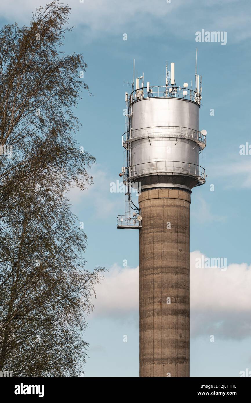 Hoher Wasserturm mit Kommunikationsantennen Stockfoto