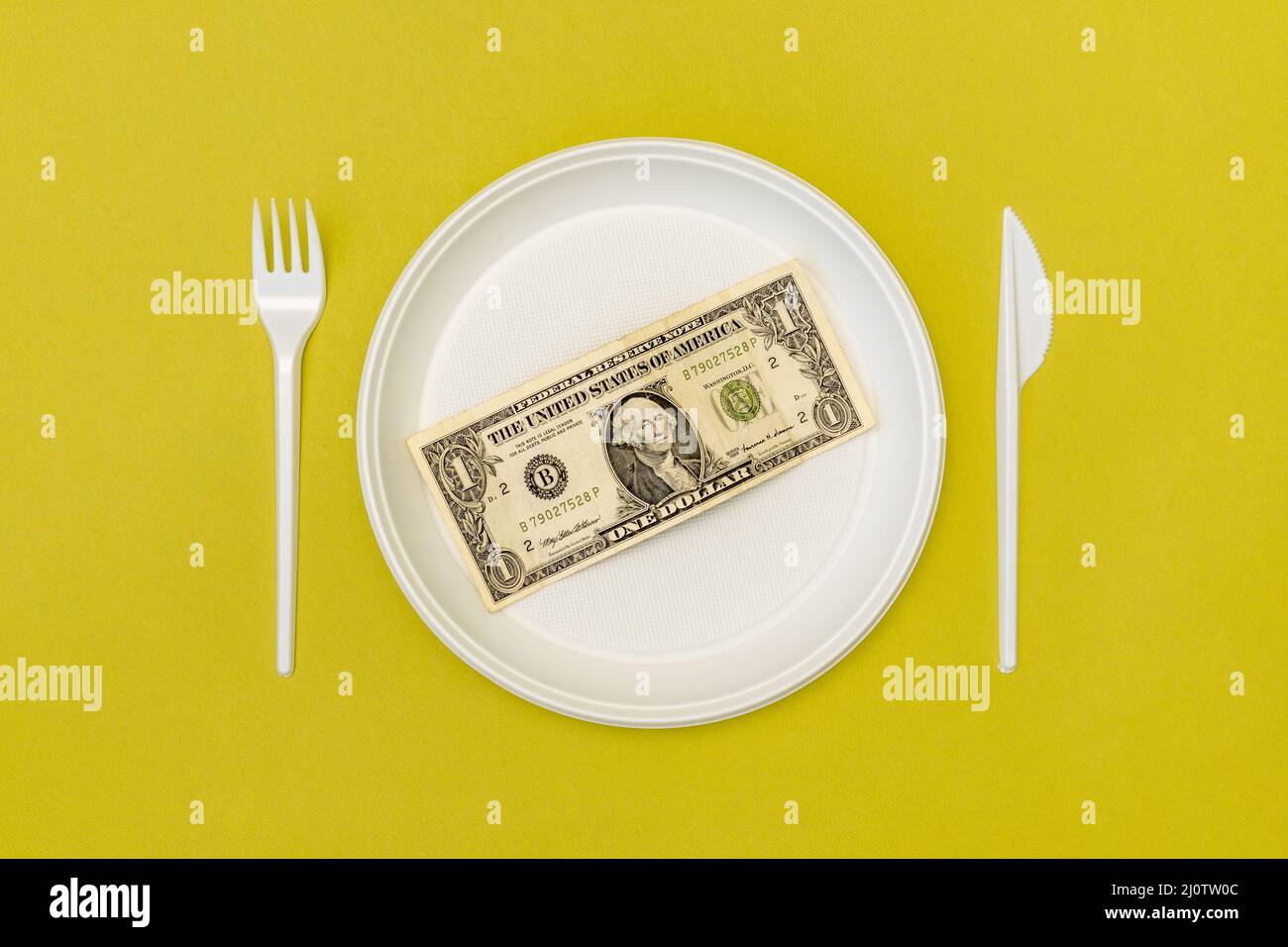 Draufsicht auf Einwegbesteck und -Teller mit Dollarschein Stockfoto