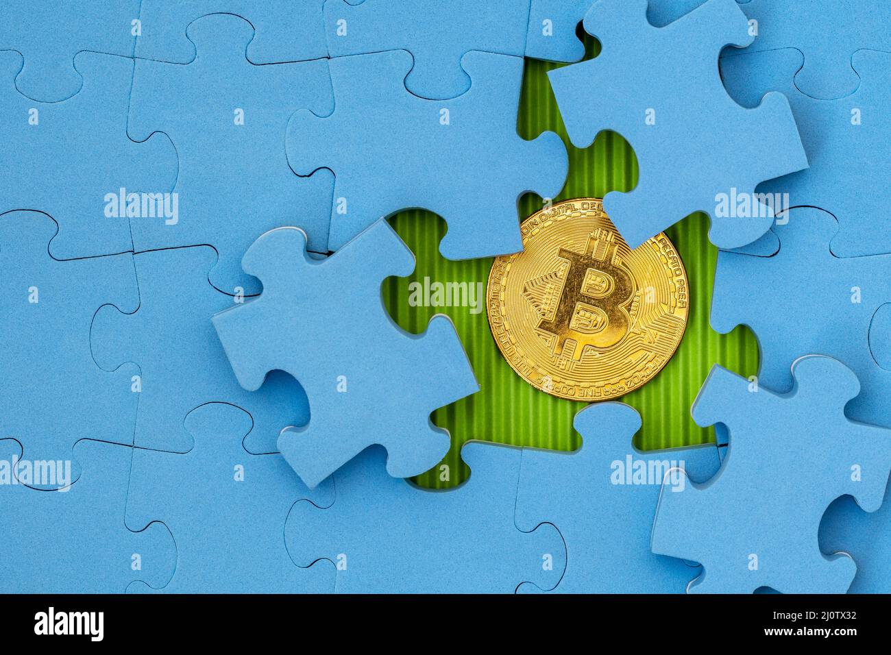 Puzzle mit goldenem Bitcoin darunter Stockfoto