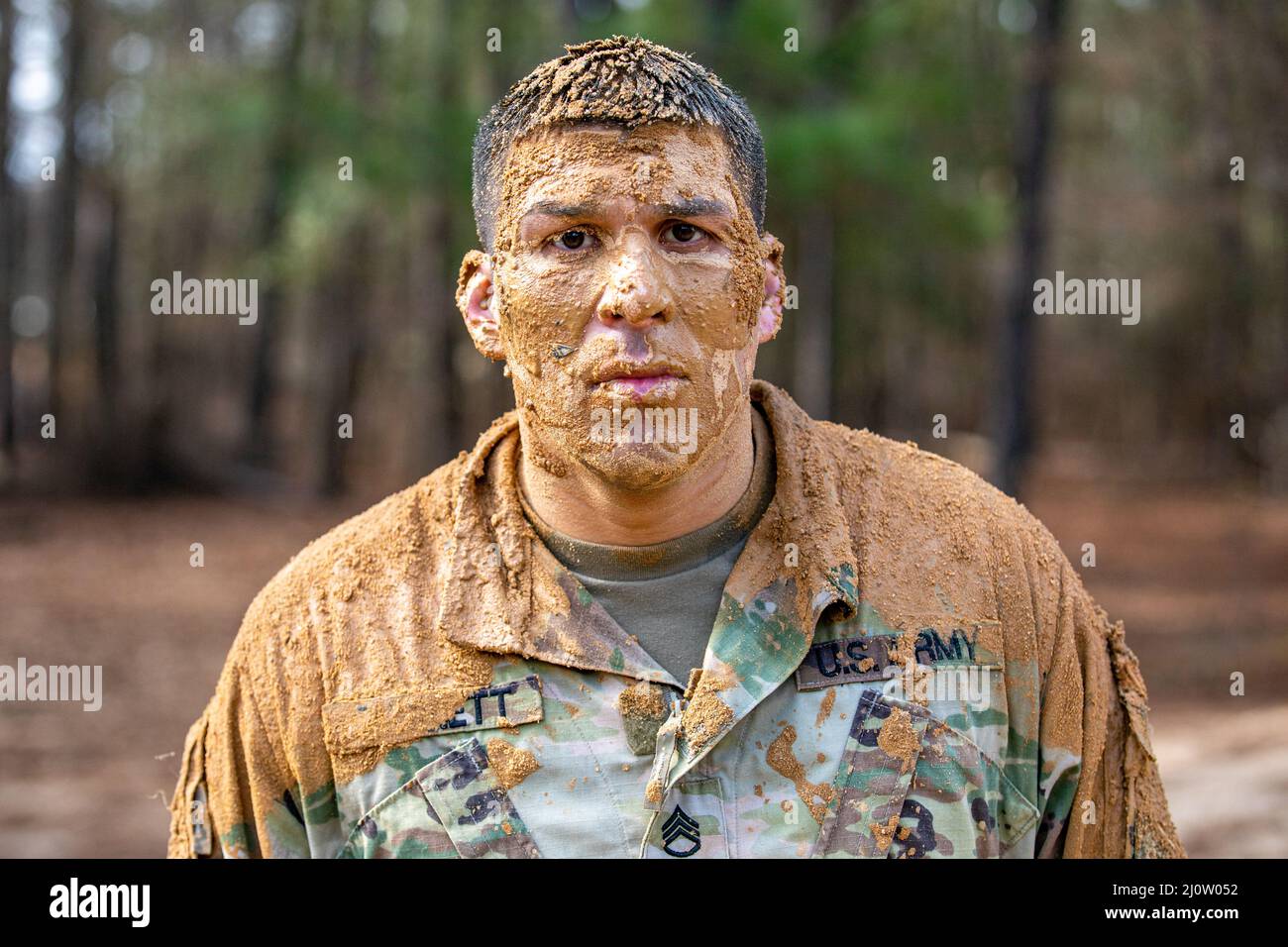 Personal Sgt. Andrew Barnett, 2. Brigade, 98. Training Division (Initial Entry Training), nachdem er am 28. Januar 2022 im Hindernisparcours im Rahmen des 2022 Best Warrior Competition der 98. Training Division in Fort Benning, Georgia, aus dem Schlamm gekrochen war. Der Best Warrior Competition würdigt Soldaten, die sich für die Werte der Armee einsetzen, den Warrior Ethos verkörpern und die Macht der Zukunft repräsentieren. (USA Army Reserve Foto von Sgt. Jeffery Harris) Stockfoto