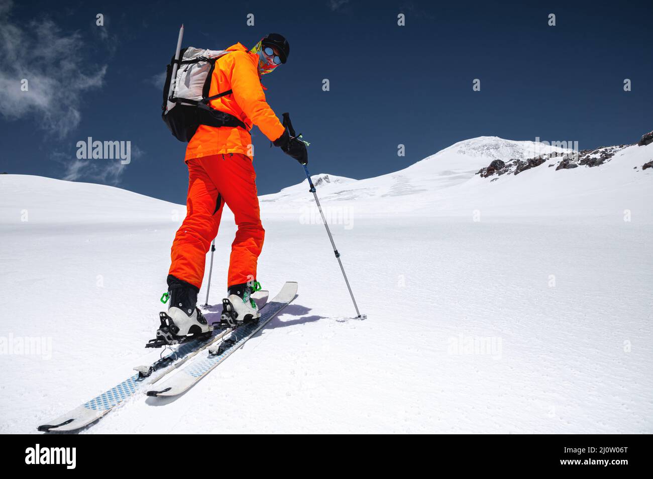 Ein Skifahrer in einem orangefarbenen Anzug Ski in einem Berg abseits der Piste Skifahren im nördlichen kaukasus des Mount Elbrus Stockfoto
