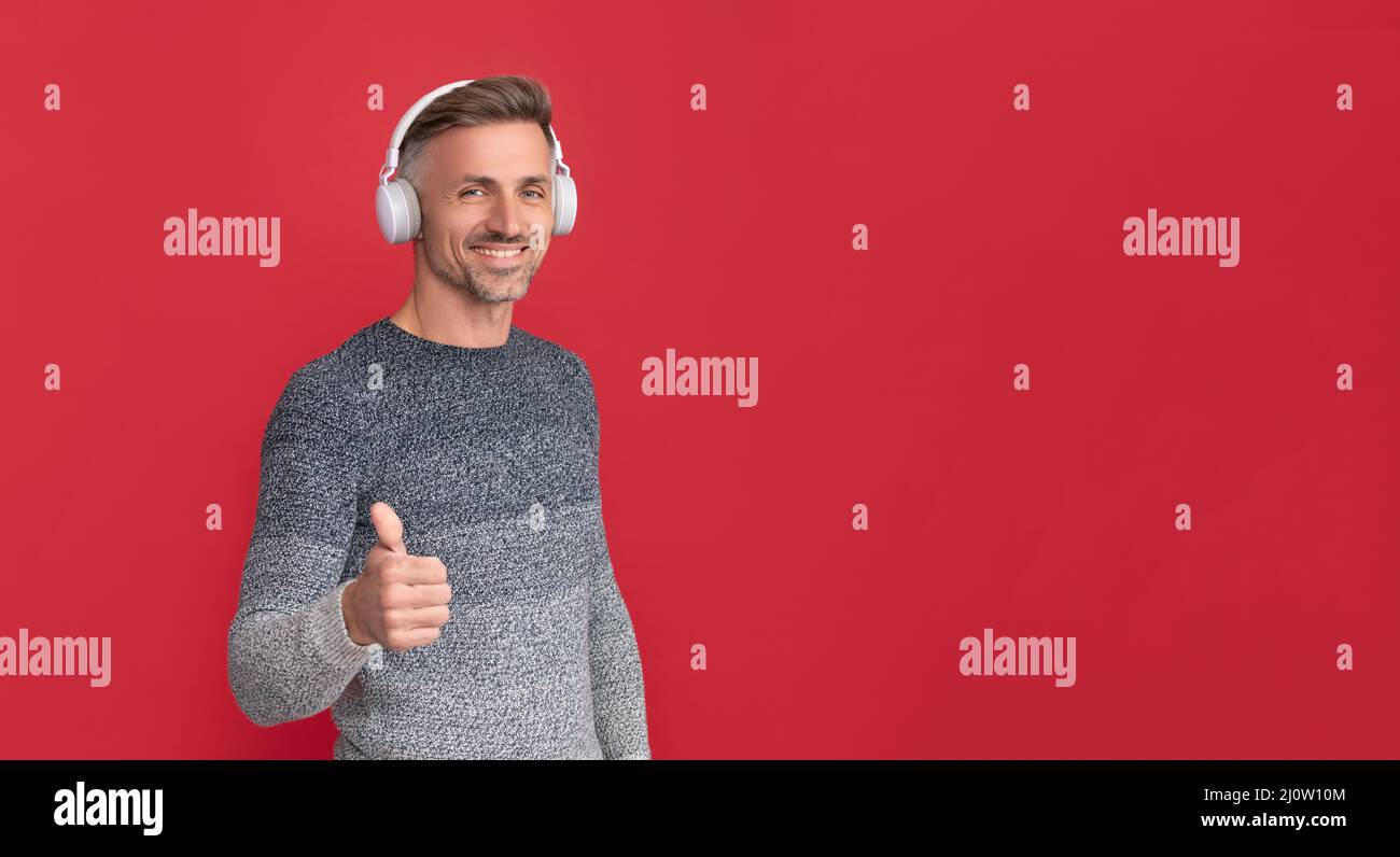 Die besten Lieder, die Sie je hören können. Glücklicher Mann, der sich die Daumen hoch für die Musik macht. Melodie Stockfoto