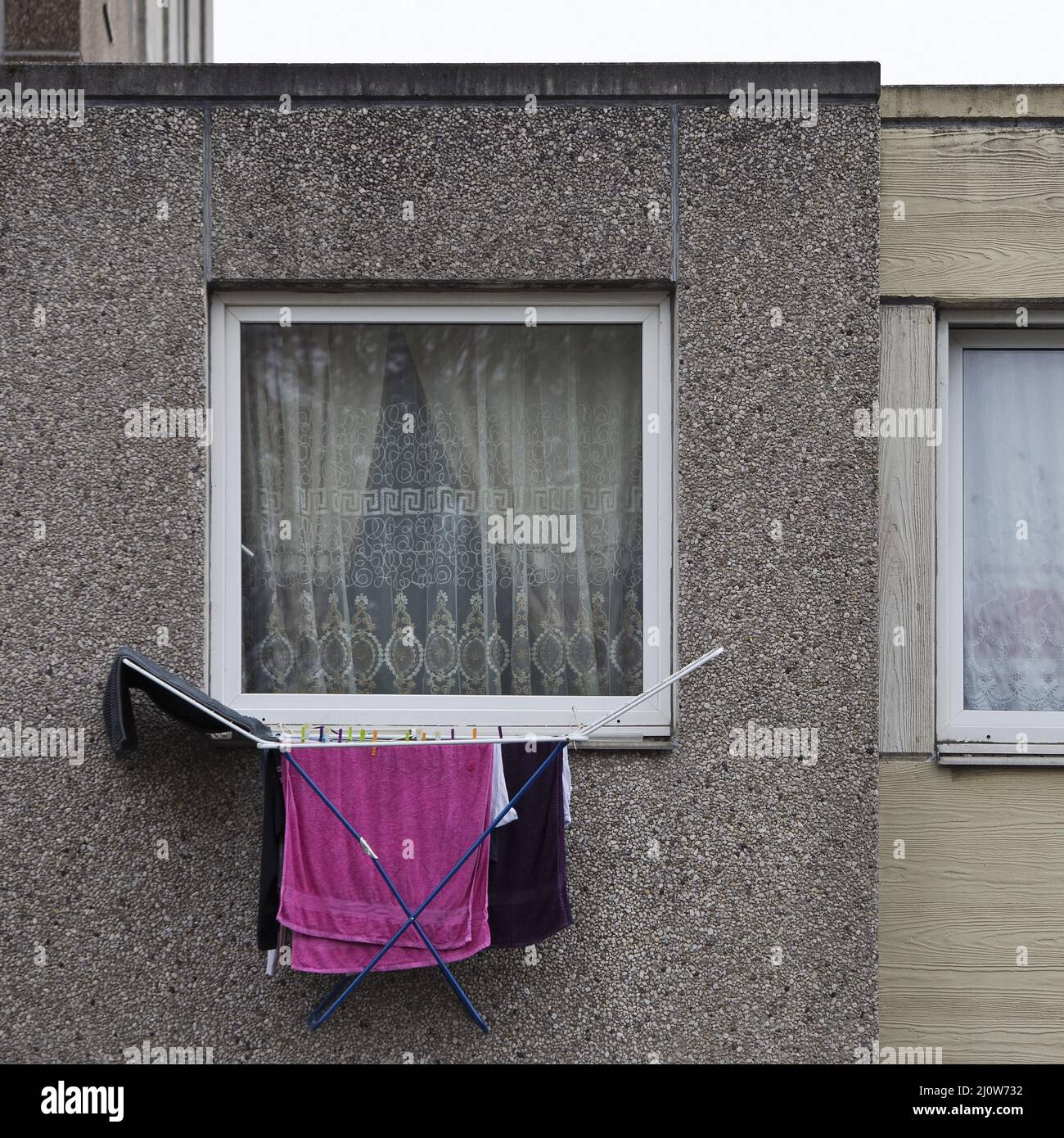 Im ersten Stock eines trostlosen Wohnblocks, Göttingen, hängen Wäschestücke aus dem Fenster Stockfoto