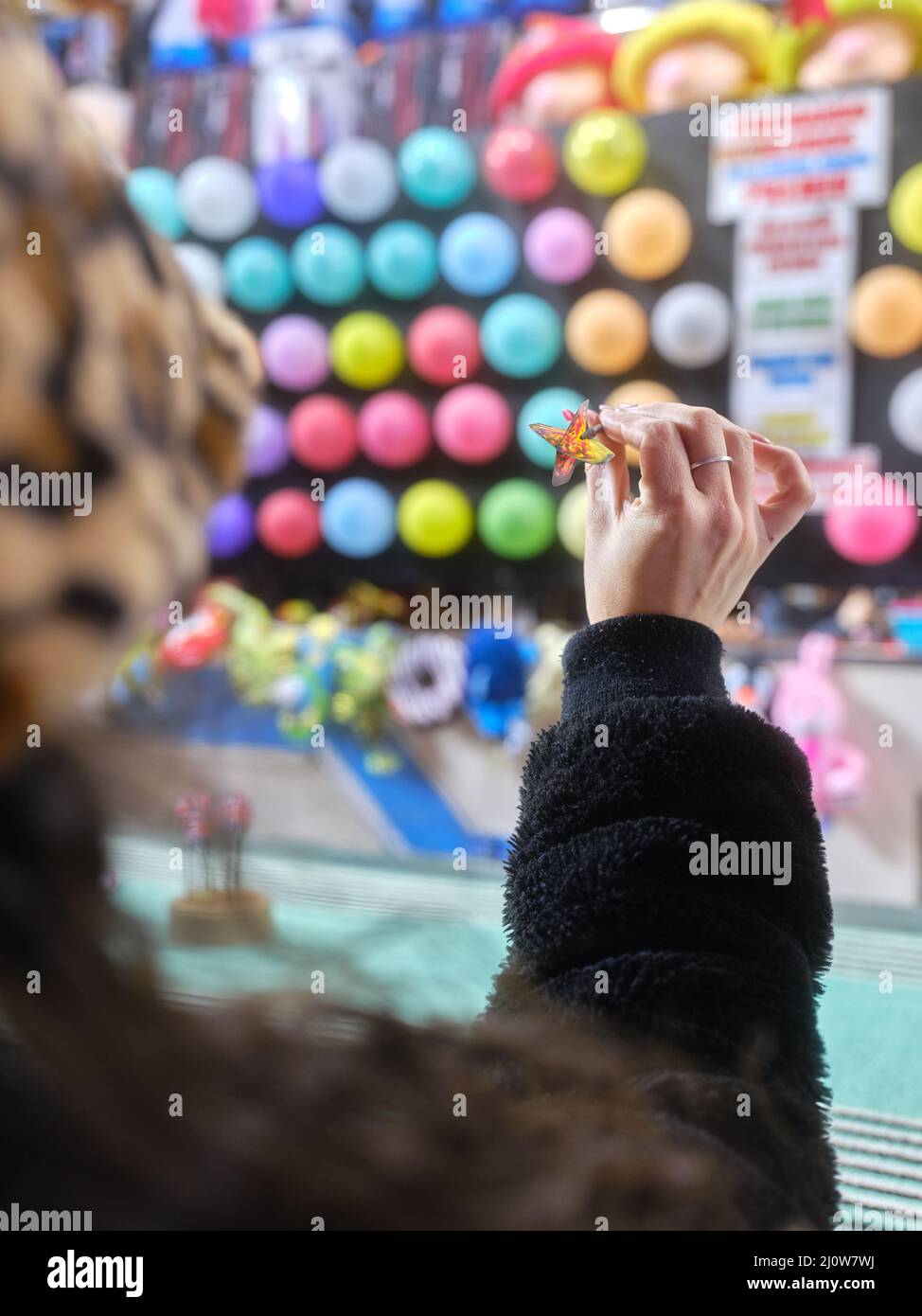 Frau wirft einen Pfeil auf einem Nachtmarkt Stockfoto