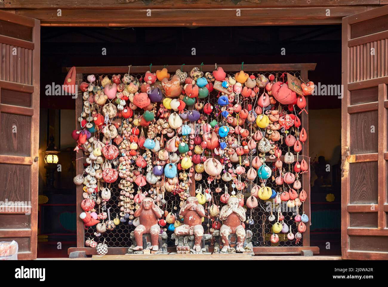 Drei Affen, die von bunten Kugeln (kukurizaru) im Yasaka Koshin-do-Tempel umgeben sind. Kyoto. Japan Stockfoto