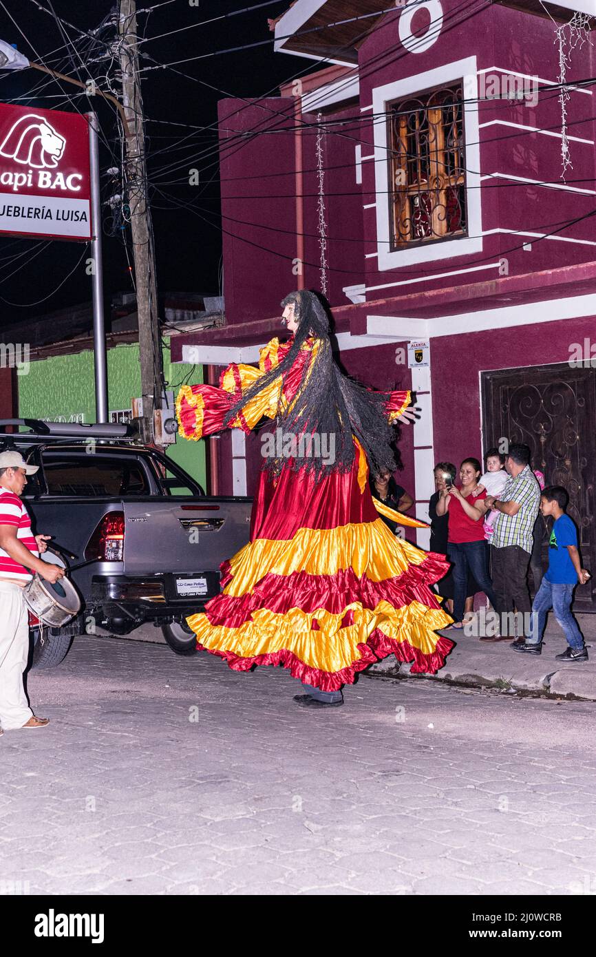 La Gigantona tanzt auf der Straße in Jinotega, Nicaragua, begleitet von einem Schlagzeuger. Stockfoto