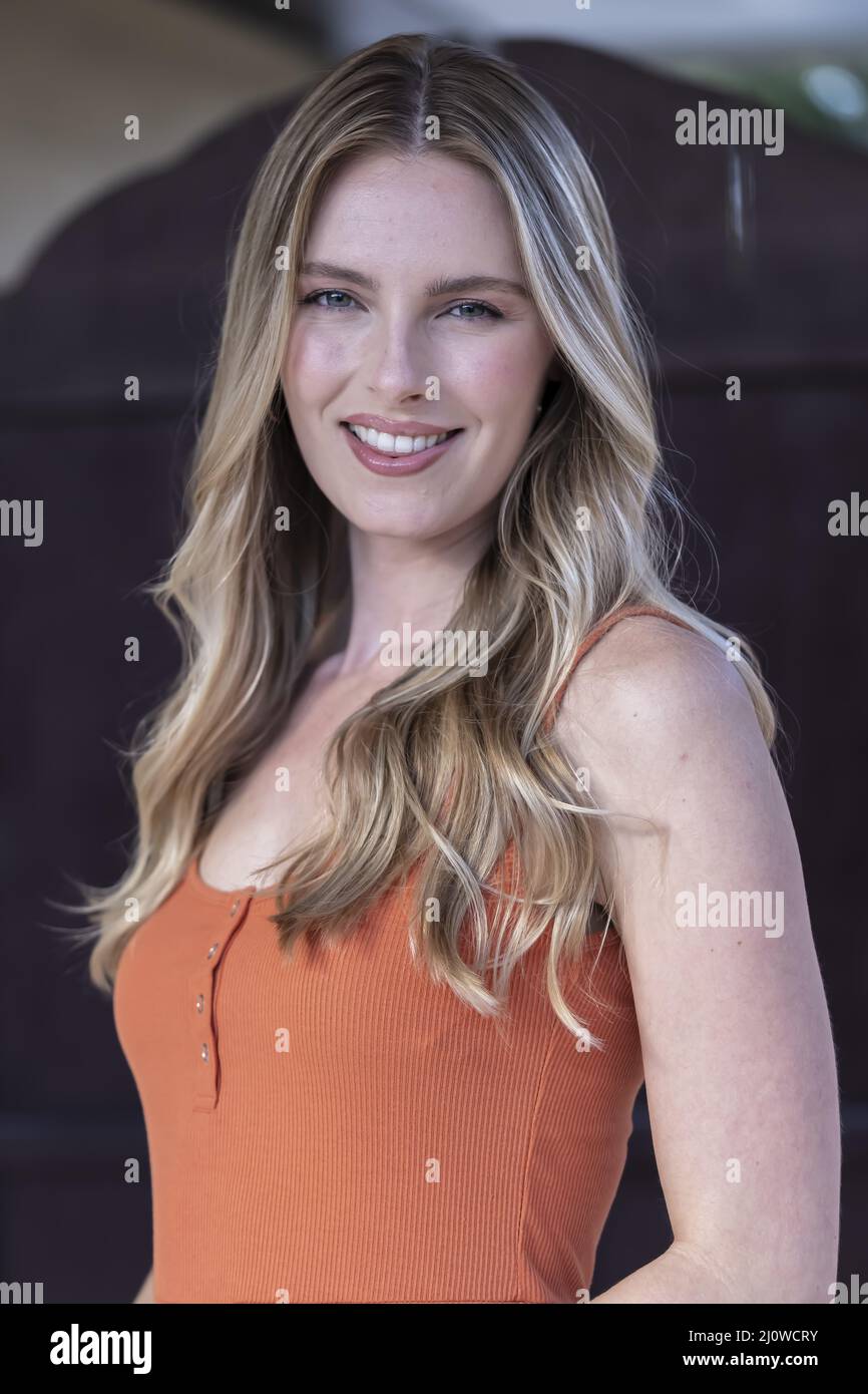 Ein schönes blondes Modell posiert im Freien, während es das warme Wetter genießt Stockfoto