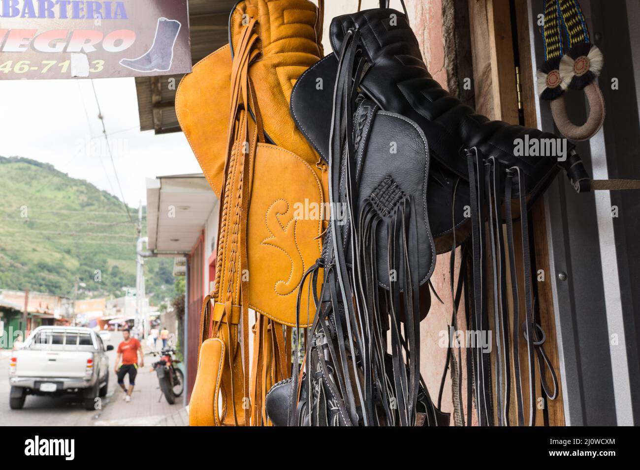 Vor einem Lederhandwerk in Jinotega, Nicaragua, hängen Sättel im zentralamerikanischen Stil. Stockfoto