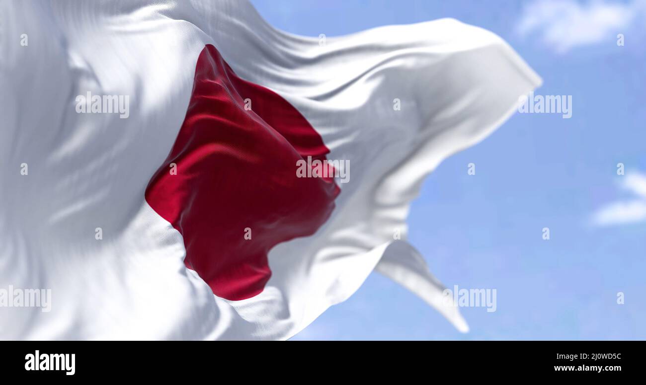 Detaillierte Nahaufnahme der Nationalflagge Japans, die an einem klaren Tag im Wind winkt Stockfoto