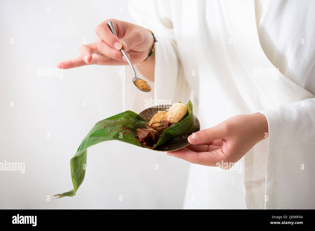 Hinzufügen von braunem Zucker zu Zongzi Stockfoto