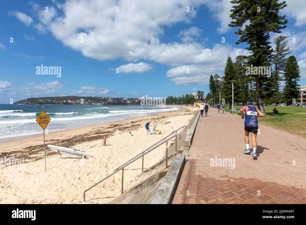 Mann trainiert beim Joggen entlang der Strandpromenade am Manly Beach in Sydney, Australien, der Strand ist wegen Überschwemmungen geschlossen Stockfoto