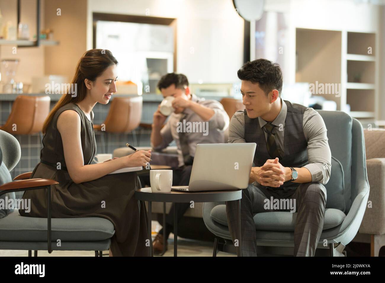 Junge Geschäftsleute mit Laptop im Coffee Shop Stockfoto