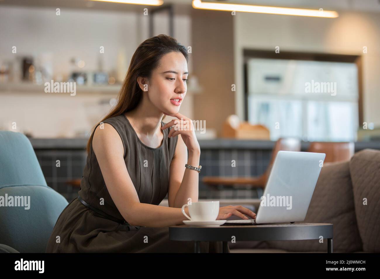 Schöne chinesische Frau arbeitet im Café Stockfoto