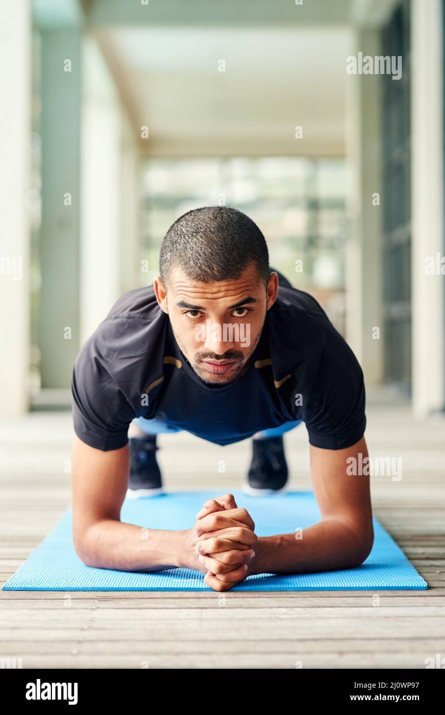 Raus und fit werden. Porträt eines sportlichen jungen Mannes, der draußen auf der Plane steht. Stockfoto