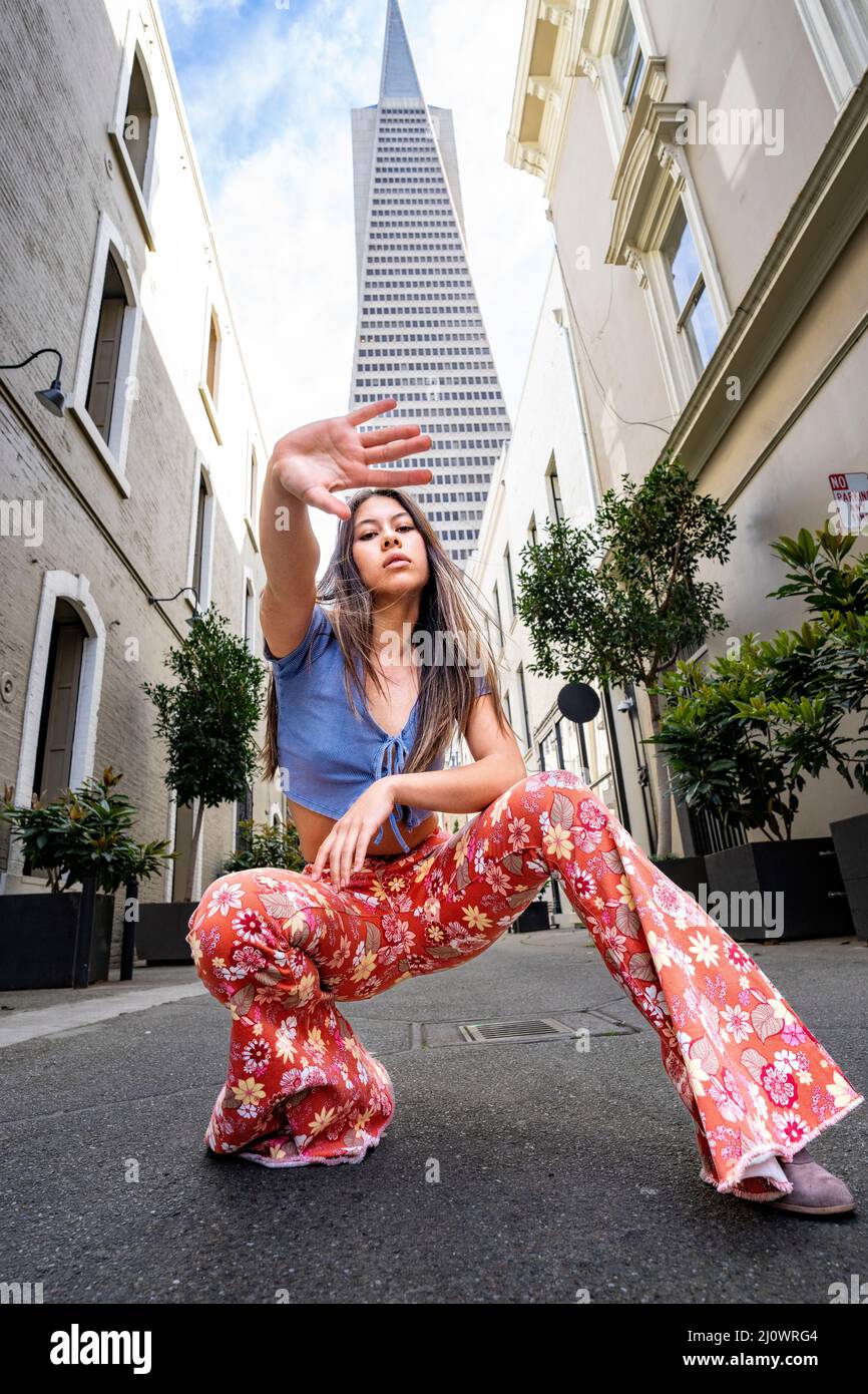 Teenager-Frau trägt Kleidung im Stil 60s mit der legendären Skyline von San Francisco im Hintergrund Stockfoto