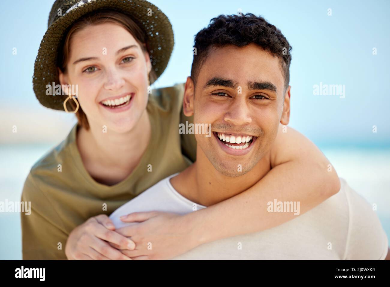 Er trägt mich, wenn ich Unterstützung brauche. Aufnahme eines jungen Paares, das einen Tag am Strand genießt. Stockfoto