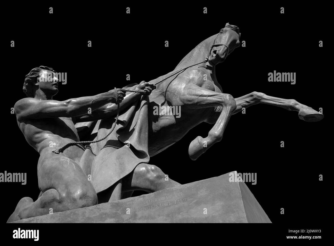 Pferd und Mann antike Skulptur der Anitschkow-Brücke in Sankt Petersburg. Monument isoliert auf schwarzem Hintergrund Stockfoto