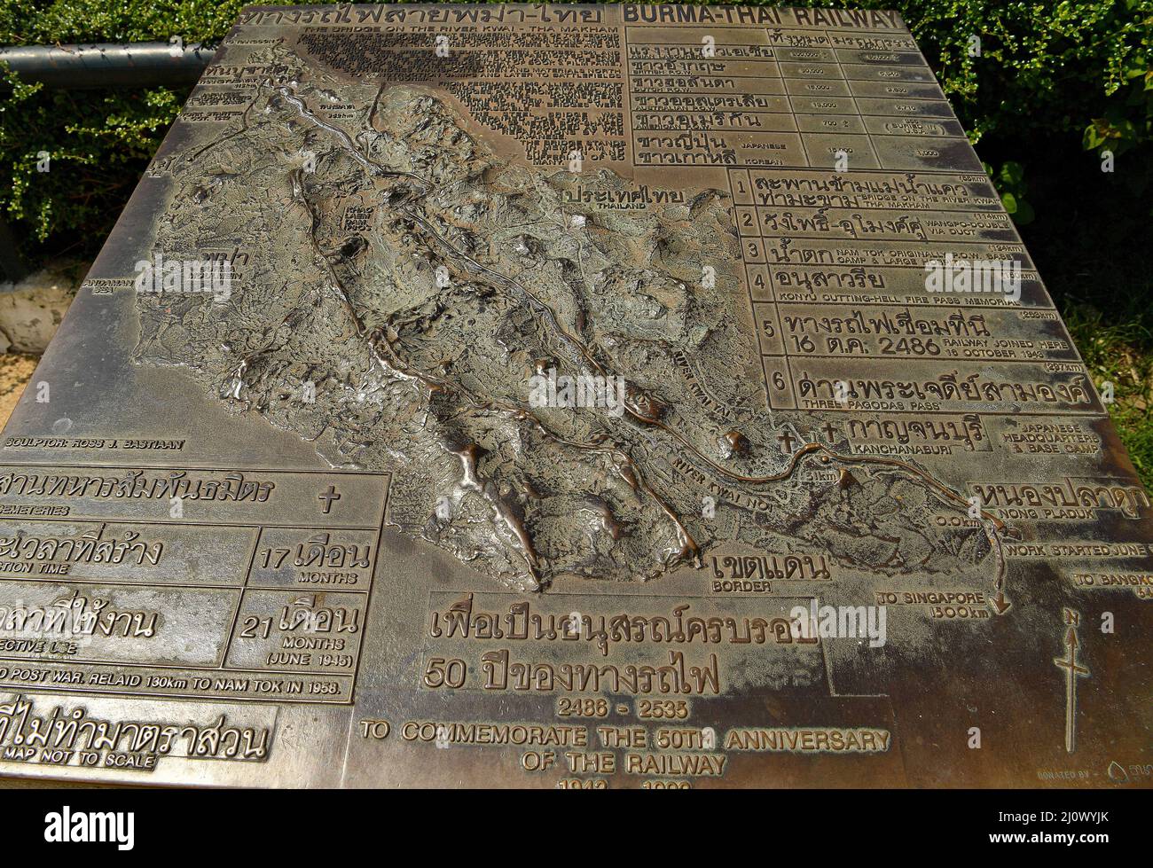 Ansicht einer Gedenktafel zur Geschichte der Brücke am Fluss Kwai, die etwa 140 km westlich der Hauptstadt Bangkok liegt. Gebaut von den Japanern, um eine Route zwischen Thailand und Myanmar zu schaffen, die als Todesbahn bekannt ist. Über 60.000 alliierte Gefangene bauten die Brücke während der japanischen Besetzung Thailands, 13,000 Gefangene kamen während des Baus ums Leben. Die im Oktober 1943 fertiggestellte Eisenbahnlinie verbindet die südliche Hauptlinie Thailands von Bangkok aus. Stockfoto
