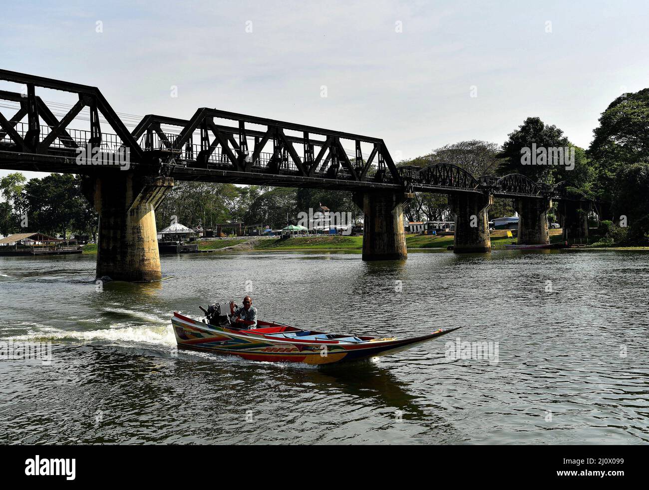 Kanchanaburi, Thailand. 21.. Februar 2022. Ein thailändisches Langschwanz-Boot passiert die Brücke auf dem Fluss Kwai, etwa 140 km westlich der Hauptstadt Bangkok. Gebaut von den Japanern, um eine Route zwischen Thailand und Myanmar zu schaffen, die als Todesbahn bekannt ist. Über 60.000 alliierte Gefangene bauten die Brücke während der japanischen Besetzung Thailands, 13,000 Gefangene kamen während des Baus ums Leben. Die im Oktober 1943 fertiggestellte Eisenbahnlinie verbindet die südliche Hauptlinie Thailands von Bangkok aus. (Foto von Paul Lakatos/SOPA Images/Sipa USA) Quelle: SIPA USA/Alamy Live News Stockfoto