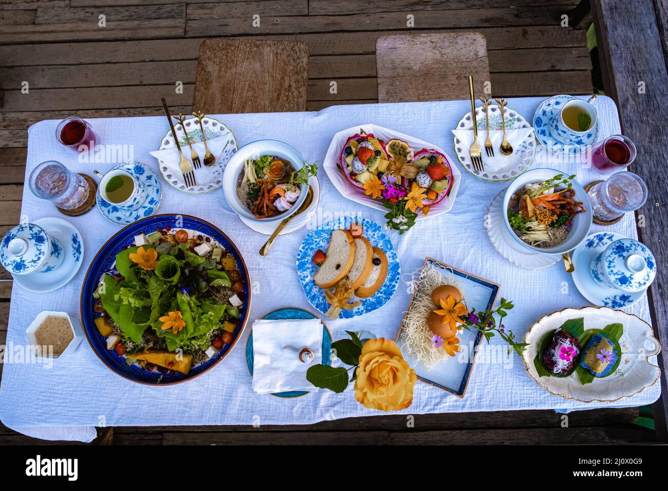 Frühstückstisch in den Bergen von Thailand Chiang Mai, Holztisch serviert festlichen Tisch mit hausgemachten Speisen und Getränken, frisches Obst Stockfoto