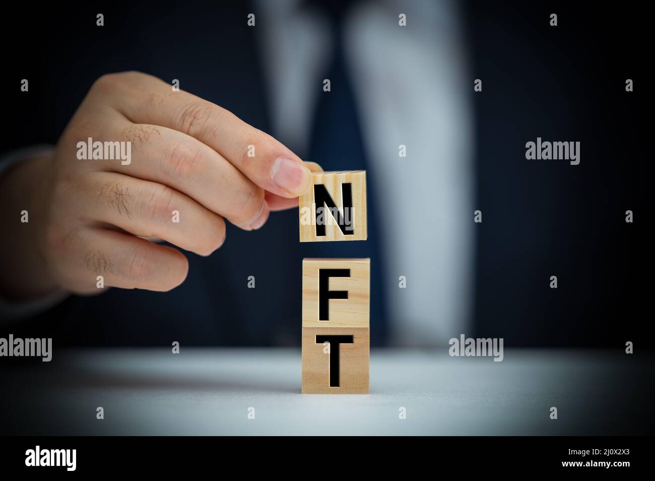 Man stellt Wort NFT aus Blöcken zusammen. Nicht fungibler NFT-Token. Technische Zusammenfassung. NFT-Konzept Stockfoto