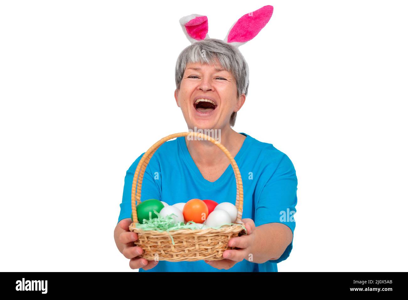Ältere Frau in Hasenohren und mit osterkorb isoliert auf weißem Hintergrund Stockfoto