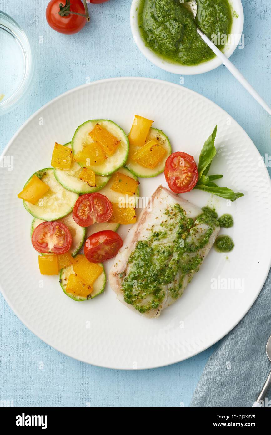 Keto-Abendessen mit weißem Fisch. Backofen-Filet aus Kabeljau, Hecht mit Gemüse und Pesto Stockfoto