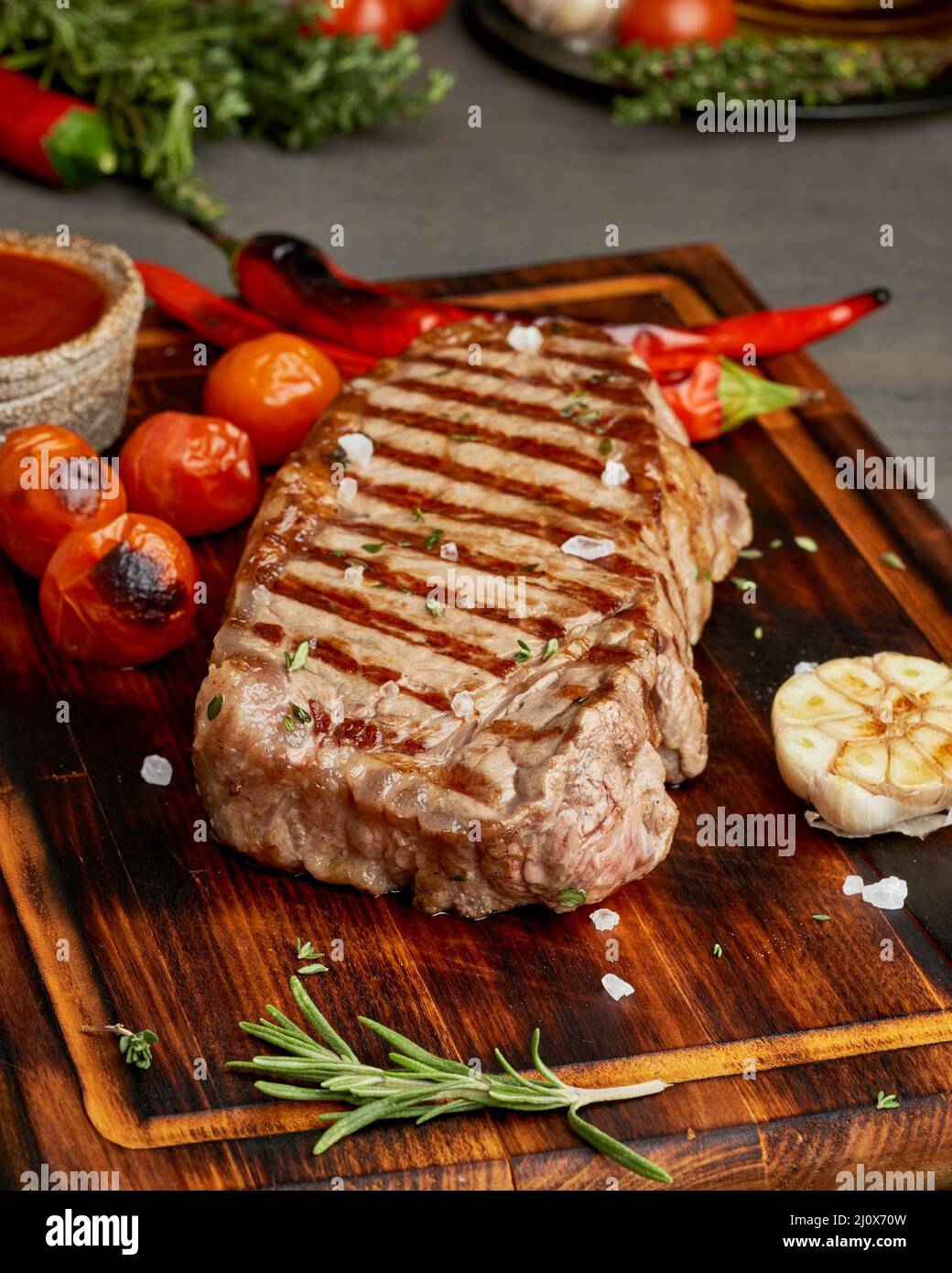 Vollkorbsteak, gebratenes Striploin auf Holzschneidebrett. Keto ketogene Diät. Nahaufnahme, Seitenansicht Stockfoto