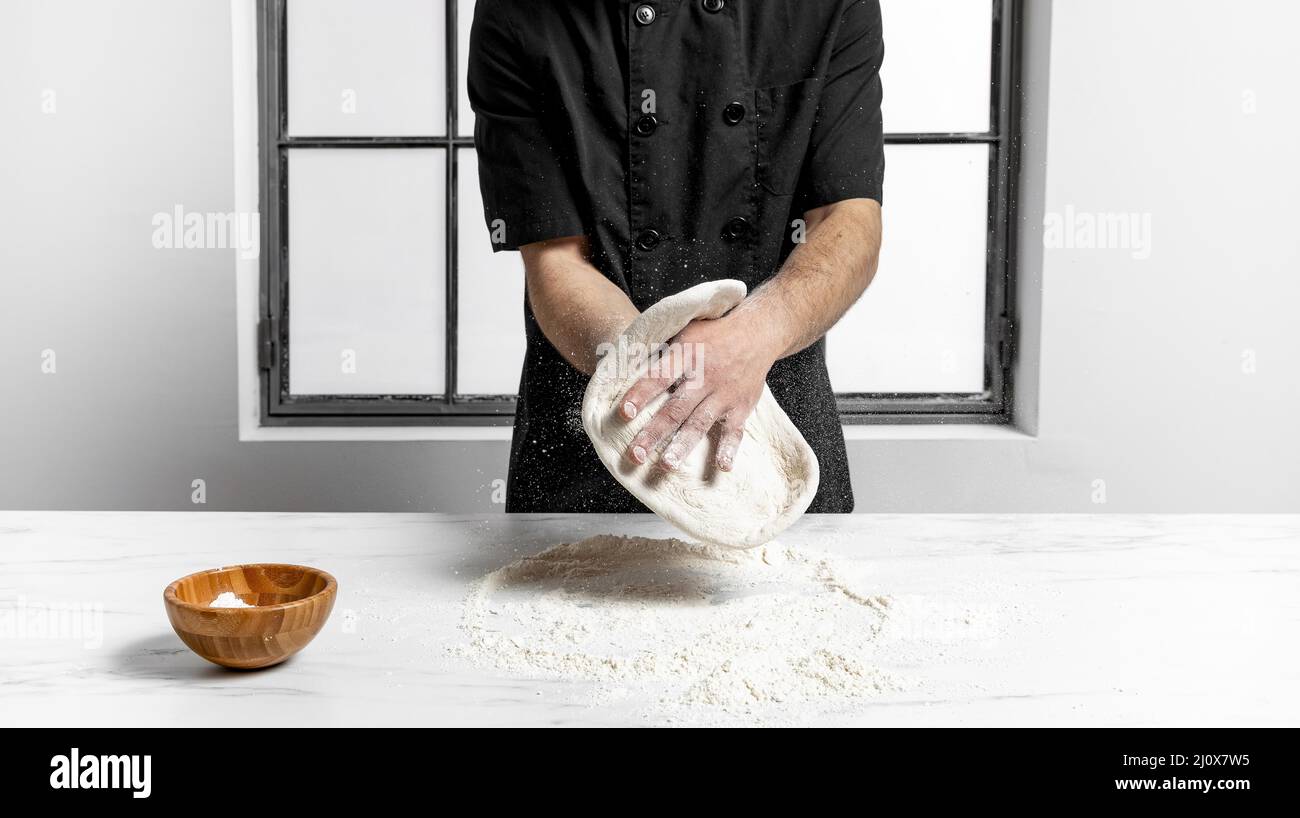 Vorderansicht Mann knetet Pizzateig. Hochwertige Fotos Stockfoto