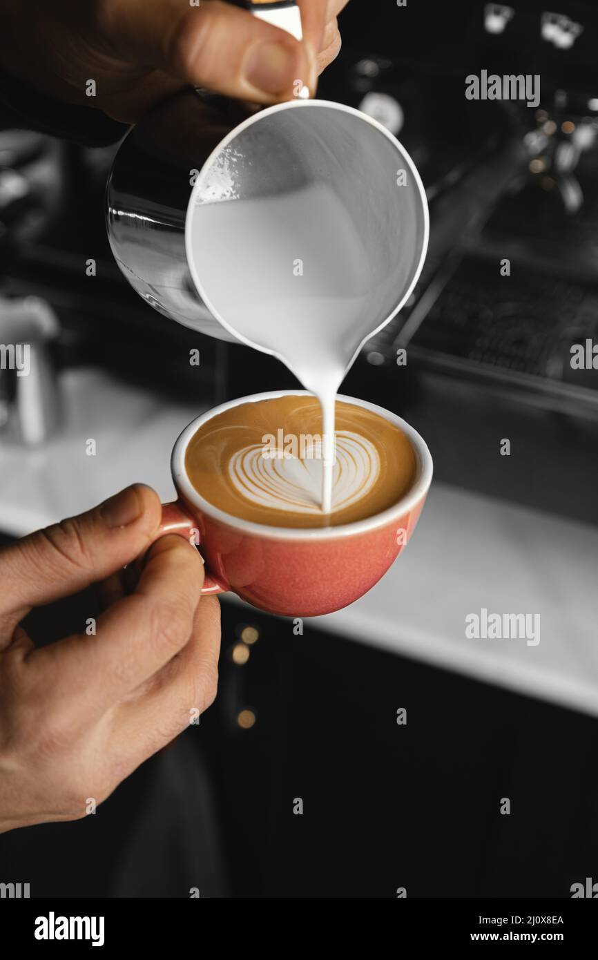 Nahaufnahme von Hand giessenden Milchkaffee 2. Hochwertiges, schönes Fotokonzept Stockfoto
