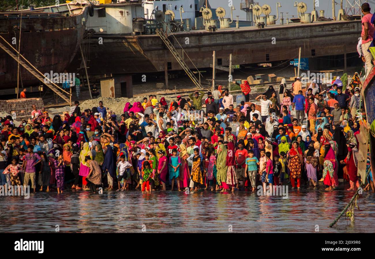 Narayanganj. 21. März 2022. Nach einem Fährunfall in Narayanganj, Bangladesch, am 20. März 2022 werden Zuschauer am Flussufer gesehen. Rettungskräfte haben sechs Leichen aus einem Fluss im Bezirk Narayanganj außerhalb von Bangladeschs Hauptstadt Dhaka geborgen, nachdem eine Fähre mit einem anderen Schiff kollidierte und am Sonntag gekentert war, sagte ein hochrangiger Beamter. Quelle: Xinhua/Alamy Live News Stockfoto
