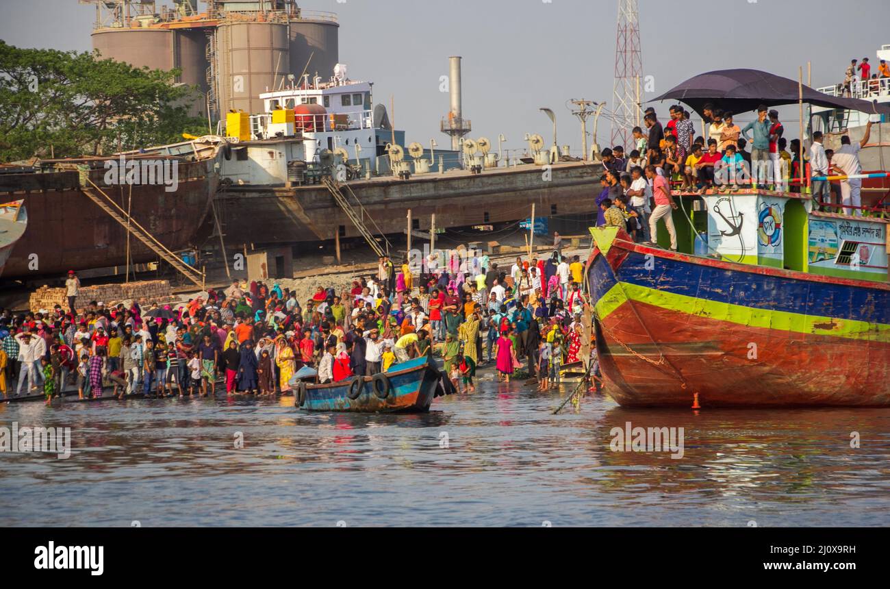 Narayanganj. 21. März 2022. Nach einem Fährunfall in Narayanganj, Bangladesch, am 20. März 2022 werden Zuschauer am Flussufer gesehen. Rettungskräfte haben sechs Leichen aus einem Fluss im Bezirk Narayanganj außerhalb von Bangladeschs Hauptstadt Dhaka geborgen, nachdem eine Fähre mit einem anderen Schiff kollidierte und am Sonntag gekentert war, sagte ein hochrangiger Beamter. Quelle: Xinhua/Alamy Live News Stockfoto